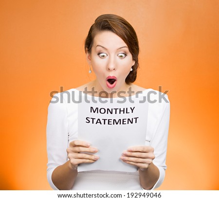 Closeup portrait shocked, funny looking business woman, disgusted at monthly statement, can\'t believe her eyes, isolated orange background. Negative human emotion, facial expression, feeling. Bad news