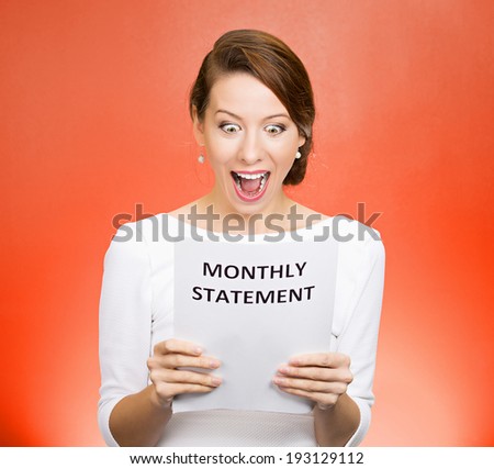 Closeup portrait happy excited, young business woman looking at monthly statement glad to pay off bills, isolated orange background. Positive emotions, facial expressions. Financial success, good news