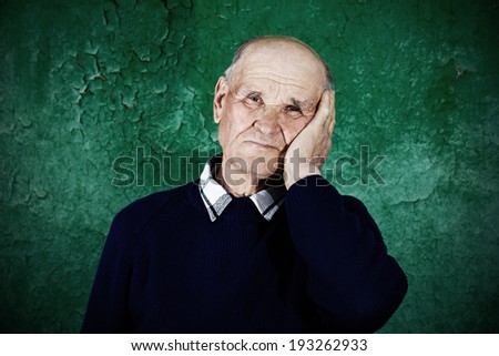 Closeup portrait, senior, sad old man thinking, daydreaming, looking away, palm, hand on face, isolated dark green background. Human emotions, facial expressions, feelings, life perception, reaction
