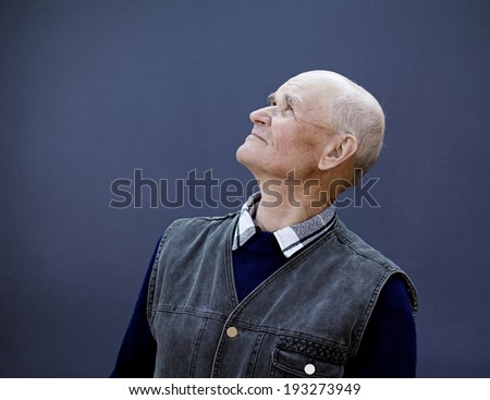 Closeup portrait senior, elderly, mature man, grandfather looking up with hope, thinking, daydreaming, isolated black background. Human facial expressions, emotions, feelings, reaction life perception