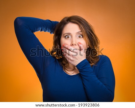 Closeup portrait, headshot startled woman, looking shocked, surprised, full disbelief, hand on head, mouth isolated orange background. Negative human emotions, facial expressions, feelings, reaction