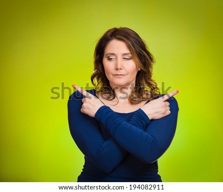Closeup portrait confused young woman pointing in two different directions, not sure which way to go in life, isolated green background. Negative emotions, facial expressions, feeling body language