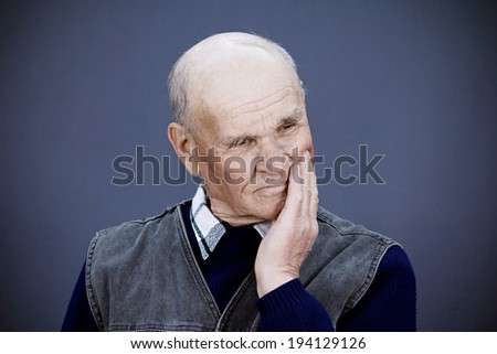 Closeup portrait senior, elderly, mature, depressed man sad, deep in thought, thinking, realizing truth, looking down isolated blue background. Human face expressions, emotions, feeling, reaction