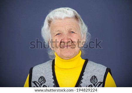 Closeup portrait, headshot happy, smiling, laughing, senior old woman, grandmother, isolated blue background. Positive human emotions, facial expressions, life perception, feelings, attitude, reaction