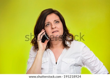 Closeup portrait middle aged angry business woman, corporate employee talking on cell phone, having unpleasant conversation, isolated green background. Negative emotions, facial expressions, reaction