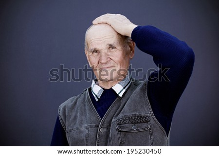 Closeup portrait, headshot senior, elderly, mature man, old sad worker, hand on head, looking troubled, deep thought, thinking, isolated blue background. Human emotions, facial expressions, reaction