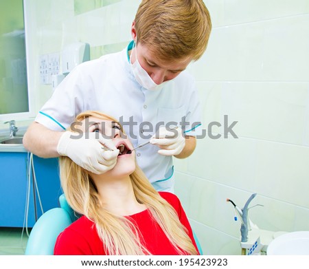 Closeup portrait young female, woman, patient sitting in dentist chair, office, wide open mouth getting oral thorough examination, procedure done by doctor isolated background clinic office, equipment