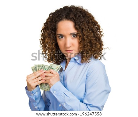 Closeup portrait greedy young woman corporate business employee, worker, student holding dollar banknotes tightly, isolated white background. Negative human emotion facial expression, feeling attitude