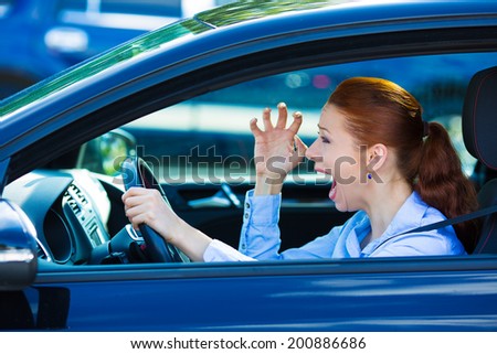 Closeup portrait displeased angry pissed off aggressive woman driving car, shouting at someone, hands up in air isolated traffic background. Emotional intelligence concept. Negative human expression