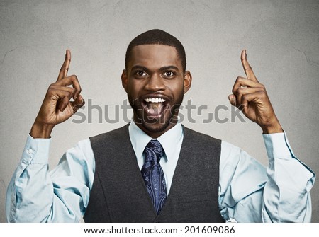 Closeup portrait young business man pointing up  having idea, solution, showing with index finger number one, isolated black grey background. Positive human emotions, facial expressions, symbols, sign