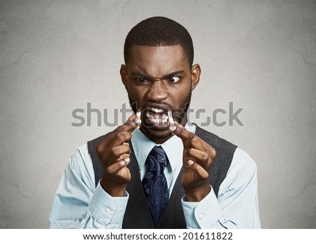 Closeup portrait, headshot, young, handsome, unhappy, angry  business man, corporate executive breaking cigarette, isolated black grey background. Life style changes. Human face expressions, emotions