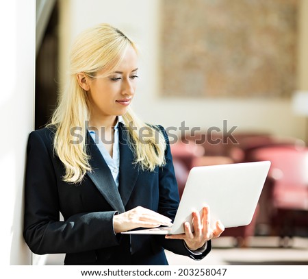 Business technology, internet hotel concept. Closeup portrait happy smiling businesswoman working on tablet pc computer checking email isolated background corporate office hallway. Positive expression