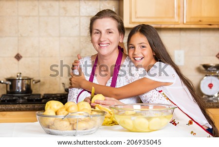 Group portrait of happy, smiling mother and daughter cooking dinner, preparing food isolated background home kitchen. Positive family emotions, face expression, life perception. Healthy eating concept