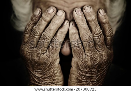 Closeup portrait sad depressed, stressed, thoughtful, senior, old woman, gloomy, worried, covering her face, isolated black background. Human face expressions, emotion, feelings, reaction, attitude