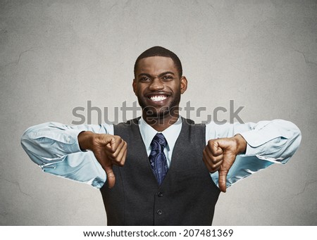 Closeup portrait sarcastic young man showing two thumbs down sign hand gesture, happy that someone made mistake, lost, failed isolated grey background. Negative emotions, facial expressions, feelings