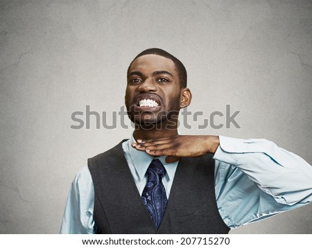 Closeup portrait, angry, mad young executive man gesturing with hand to stop talking, cut it out, or he will take your head off isolated grey background. Negative emotion, facial expression feelings