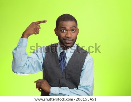 Closeup portrait rude, difficult, angry young executive businessman gesturing with fingers against temple, are you crazy? Isolated green background. Negative human emotion, facial expression, feelings