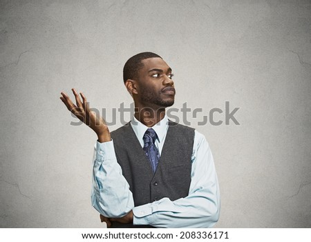 Closeup portrait dumb clueless surprised young executive man, arm out asking why what problem so who cares I don\'t know isolated grey color background. Negative human emotion facial expression feeling