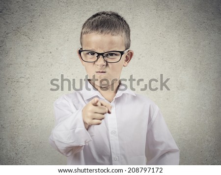 Closeup portrait angry, mad child disguised as boss, executive businessman, pointing finger at someone, displeased, isolated grey background. Human face expressions, emotions, feelings, body language