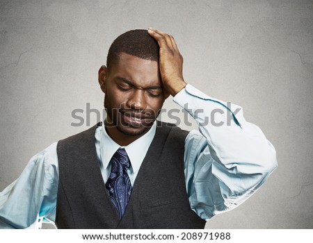 Closeup portrait man with sad expression, isolated on grey, black background. Human emotions, body language, life perception