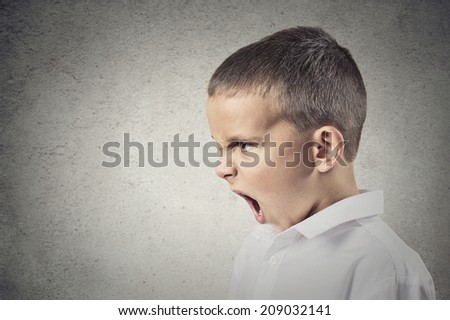 Headshot, side view Portrait Angry Child Screaming isolated grey wall background. Negative Human face Expressions, Emotions, Reaction, Perception. Conflict, confrontation concept