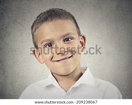 Closeup portrait, headshot, Happy, Smiling Child, Boy in white shirt, isolated grey wall background. Positive human facial expressions, emotions, feelings, life perception