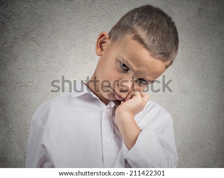 Closeup portrait very sad, depressed, alone disappointed child resting his face on hands, isolated grey wall background. Negative human emotion, face expression, feeling, life perception body language