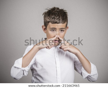 Closeup portrait young man with disgust on face, pinches his nose, something stinks, bad smell, situation isolated grey wall background. Negative emotions, facial expressions, perception body language