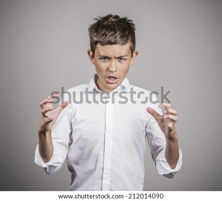 Closeup portrait bitter, displeased, pissed off, angry grumpy young man fists, arms in air about to bash something, isolated grey wall background. Negative human emotions, facial expressions, feelings