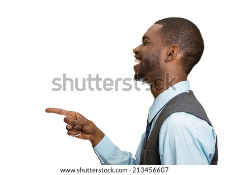 Closeup side view portrait happy young man, laughing, pointing with finger at someone, something, isolated white background. Positive human face expressions, emotions, feelings, attitude, approach