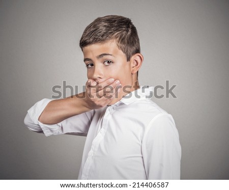 Portrait scared young handsome man looking surprised, hand covering mouth, someone shut him up, isolated grey wall background. Human emotions, facial expressions, feelings, body language, reaction