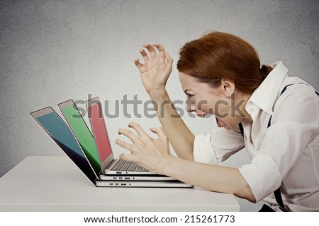 Furious, angry businesswoman screaming at computer, pissed off has nervous breakdown can\'t take it anymore isolated grey wall background. Negative human emotion face expression feeling life perception