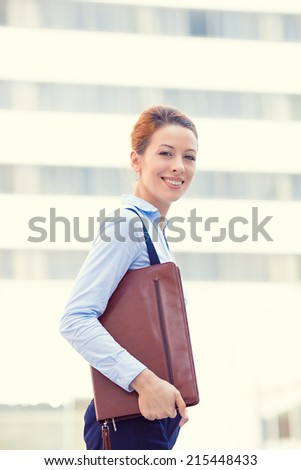 Business woman walking on background corporate office city building. Lawyer professional outside, outdoors happy holding documents. Businesswoman smiling running to work on sunny day. Face expression