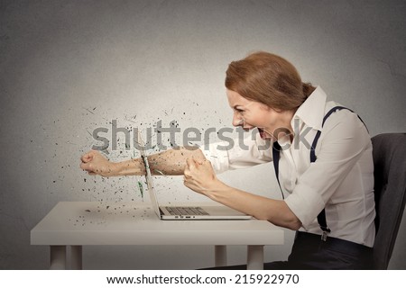 Angry, furious businesswoman throws a punch into computer, screaming. Negative human emotions, facial expressions, feelings, aggression, anger management issues