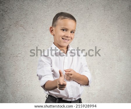 Portrait handsome young smiling man giving thumbs up pointing with fingers at camera, picking you as friend isolated grey wall background. Positive human emotion facial expression sign body language