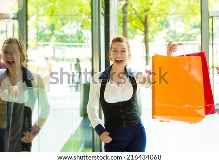 Portrait Shopping woman in New York City. Beautiful model happy, smiling summer shopper holding shopping bags standing in front of window display. Positive human emotions, facial expressions, feelings