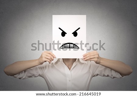 businesswoman covering her face with angry mask isolated grey wall background. Negative emotions, feelings, expressions, body language