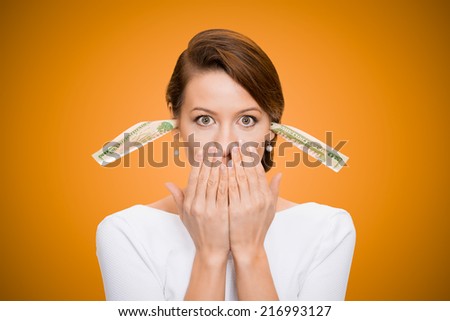 Corruption. It will keep me quiet. Bribery concept in politics, business, diplomacy. Corporate businesswoman plugs her ears with dollar banknotes, bills, covers her mouth, isolated orange background
