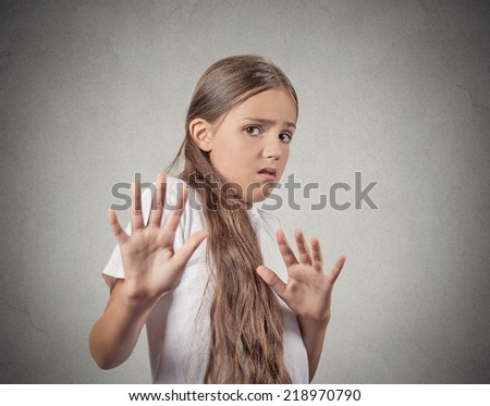 Closeup portrait teenager girl looking shocked scared trying to protect herself from unpleasant situation object thrown at her isolated grey wall background. Negative emotion Facial Expression feeling