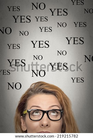 portrait of undecided woman looking up, grey wall background with yes no choices. Face expressions, emotions, feelings