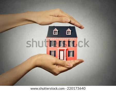 Portrait woman hands presenting small model of house, isolated grey wall background. Real estate, mortgage, home ownership concept. Safety, strong family idea. Insurance, protection
