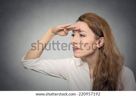 Business woman looking away into the future monitoring isolated on grey wall background. Human face expressions, emotions, body language. Future forecast, search concept