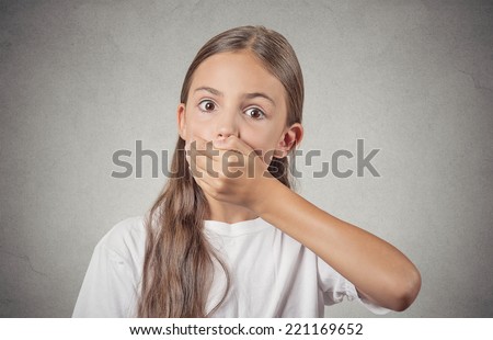 Portrait scared teenager girl looking surprised shocked hand covering mouth, someone shut her up, isolated grey wall background. Human emotions, facial expressions, feelings, body language, reaction