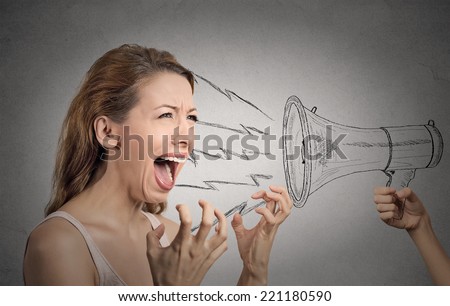 Portrait angry hysterical woman shouting against someones loud megaphone isolated grey wall background. Negative human face expressions, emotions, feelings. Lack of emotional intelligence concept