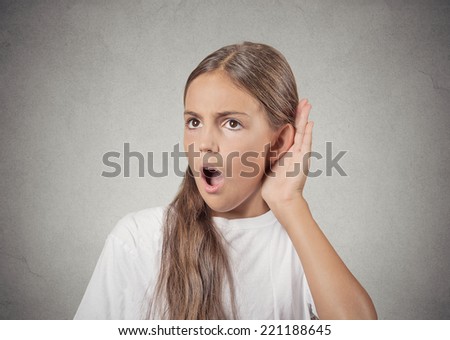 Closeup portrait nosy teenager girl hand to ear gesture carefully intently secretly listening in on juicy gossip conversation news privacy violation isolated grey background. Human face expression