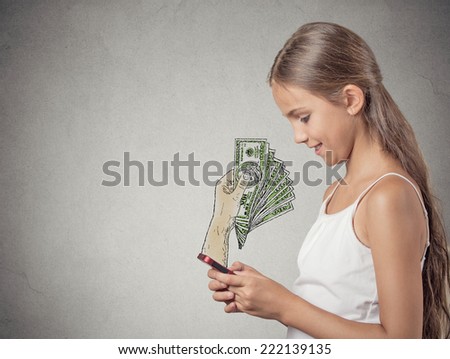 business on a go. Teenager girl working online on smartphone making earning money, hand with dollar bills banknotes coming out of phone screen, isolated grey wall background. Human face expression