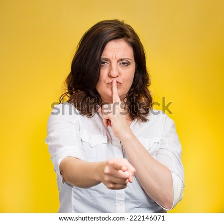 Quiet, patronize. Closeup portrait middle age woman placing finger on lips with shhh sign symbol, asking silence isolated yellow background. Negative emotion facial expression feelings, body language