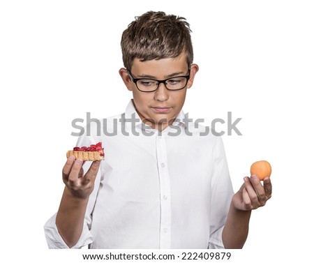 Closeup portrait young man with glasses deciding on diet, making choice sweet cookie tart fresh fruit apricot isolated white background. Weight control eating habits. Confused face expression, emotion
