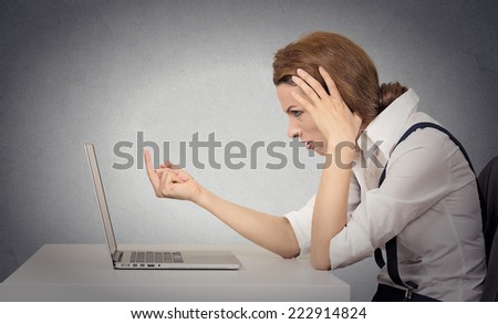 Woman angry frustrated annoyed at computer. Problems with hardware, software, internet shopping. Negative human face expressions, emotions, feelings, body language, bad attitude, life perception