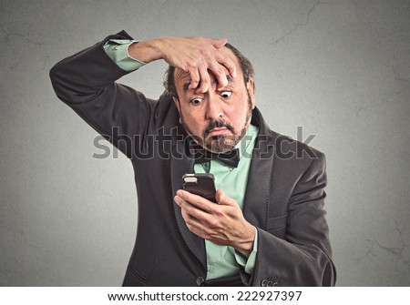 Closeup portrait sleepy funny looking middle aged man fingers keep eyes open low energy trying to stay awake holding smart phone isolated grey background. Negative facial expression emotion feeling